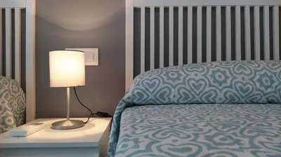 a bedroom with a bed and a lamp on a night stand at Sherryflat Arroyo in Jerez de la Frontera