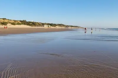 a group of people walking on the beach at Duplex Las Torres La Barrosa 3Beds - A 700m de la playa in Chiclana de la Frontera