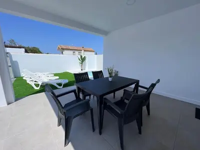 a black dining table and chairs on a patio at GRANIZO A in Chiclana de la Frontera