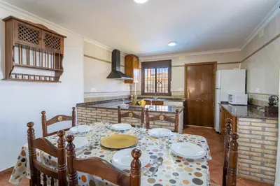 a kitchen with a table with plates on it at EntreCalas 3 chalet piscina privada Conil, Roche Viejo, Cala del Aceite in Conil de la Frontera