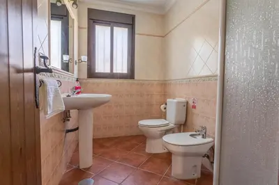 a bathroom with a sink and a toilet and a window at EntreCalas 3 chalet piscina privada Conil, Roche Viejo, Cala del Aceite in Conil de la Frontera