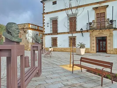 a building with a statue and a bench in a courtyard at Apartamento Boutique Kala Ático in Jerez de la Frontera