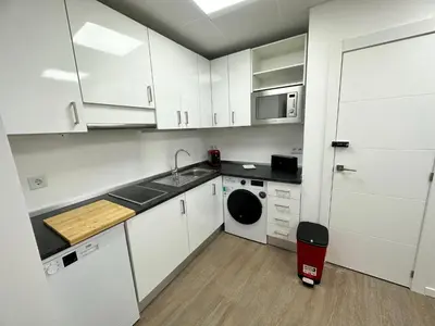 a kitchen with white cabinets and a sink and a dishwasher at Apartamento Nebro Luna, En el Corazón de Cádiz in Cádiz
