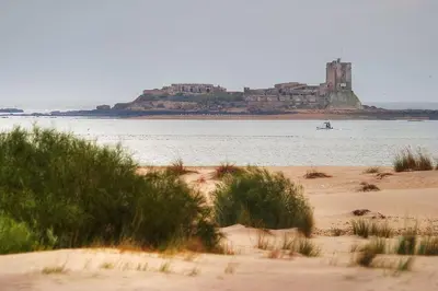 a view of a beach with a castle in the water at Enjoy the historic center of Chiclana By C. Dreams in Chiclana de la Frontera