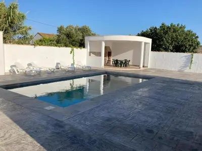 a swimming pool with chairs and a house at Villa El Lagar in Novo Sancti Petri