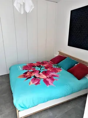 a bed with a flower on it in a room at Casa Palacio Argüeso in Sanlúcar de Barrameda