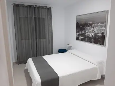 a bedroom with a white bed and a window at Apartamento Rota in Rota