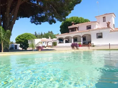 a house with a pool of water in front of it at CÁDIZ -TIPI en Chiclana de la frontera, España in Chiclana de la Frontera