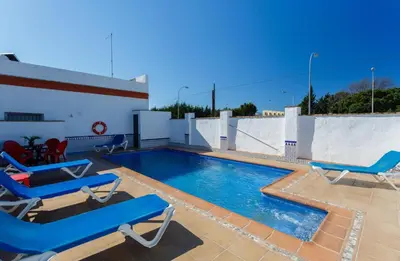 a swimming pool with blue lounge chairs on a roof at Apartamento Casa Postas II in Conil de la Frontera
