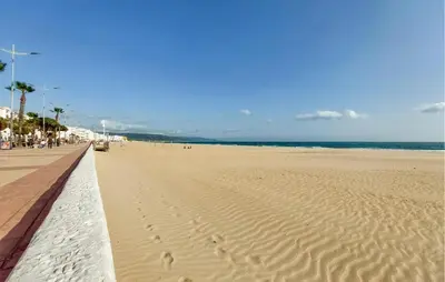 a sandy beach with a pier and the ocean at Gorgeous Home In Chiclana De La Fronter in Chiclana de la Frontera