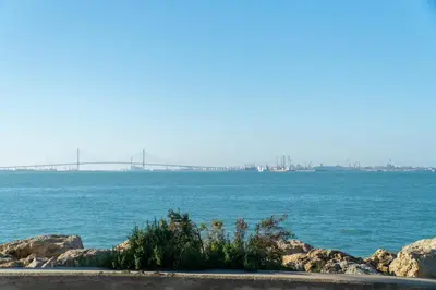 a large body of water with a bridge in the distance at Sunset Puerto Sherry in El Puerto de Santa María