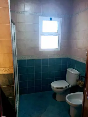 a bathroom with a toilet and a window at Habitación acogedora y sencilla in El Puerto de Santa María
