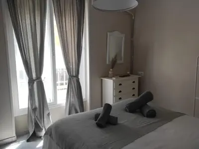 a bedroom with a bed with two pillows and a window at Plaza Plateros in Jerez de la Frontera