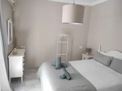 a bedroom with a bed with two blue towels on it at Plaza Plateros in Jerez de la Frontera