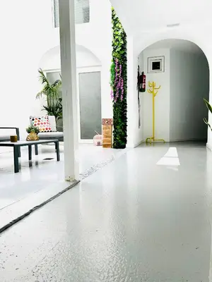 a living room with a white floor and plants at SOTAVENTO Salmarina in Sanlúcar de Barrameda