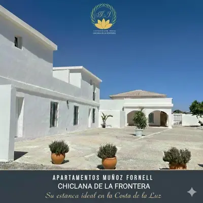 a white building with a sign in front of it at Apartamentos Muñoz Fornell 2 in Chiclana de la Frontera