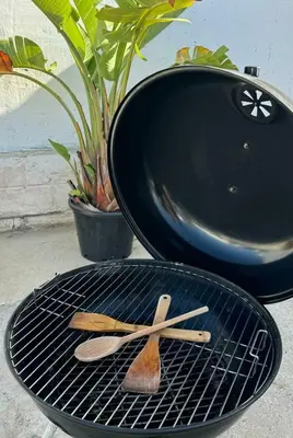a grill with two wooden spatulas and a grill at Apartamentos Muñoz Fornell 1 in Chiclana de la Frontera
