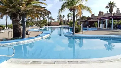 a large swimming pool with palm trees in a resort at Apartamentos Jasmund - Bungalow 117 in San Fernando