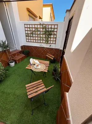 a patio with a table and a bench on a balcony at Aires de Sanlúcar in Sanlúcar de Barrameda