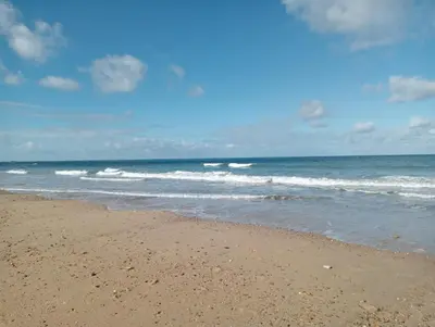 a sandy beach with waves in the ocean at Apartamento Mar III in San Fernando
