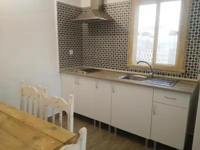 a kitchen with a sink and a table and a window at ALOJAMIENTo RURAL IZAN in Conil de la Frontera