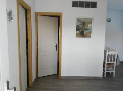 a hallway with a white door and a painting at Casa MARINERA in Cádiz