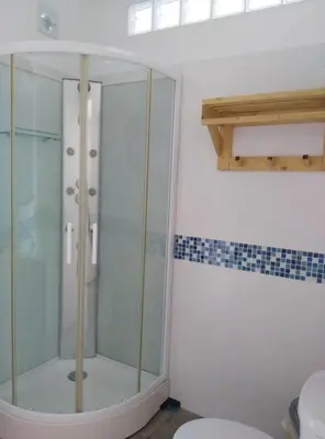 a glass shower in a bathroom with a toilet at Casa MARINERA in Cádiz