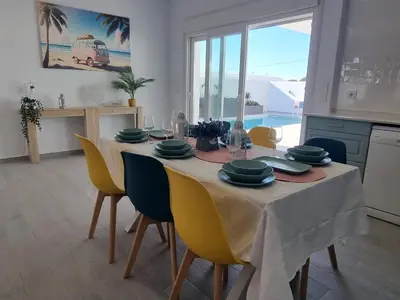 a dining room with a table with yellow chairs at Casa Calma in Conil de la Frontera