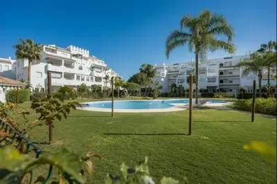 a large swimming pool with palm trees and buildings at Isla Candor free parking by Staycare in Rota