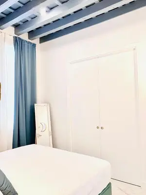 a white bedroom with a bed and a cabinet at inncadiz Los Balbos apartment in Cádiz
