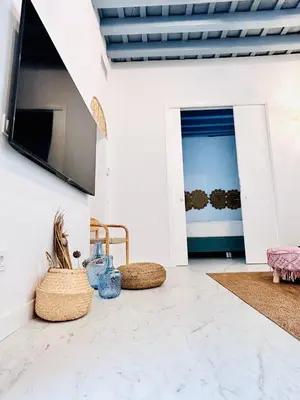 a living room with two wicker chairs and a tv at inncadiz Los Balbos apartment in Cádiz