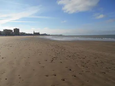 a beach with footprints in the sand and the ocean at Apartamento Caracola Comfortable holiday residence in Chipiona