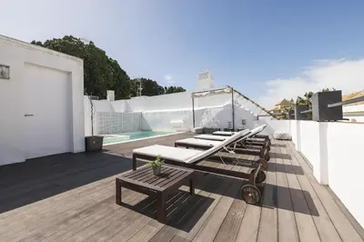 a rooftop deck with lounge chairs and a pool at Luxe Madre de Dios in Sanlúcar de Barrameda