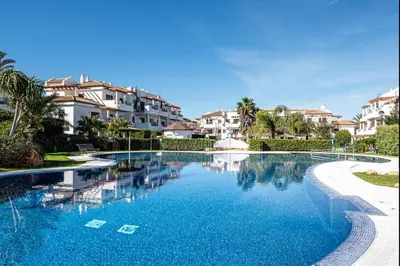 a swimming pool in a resort with houses in the background at coto 7 8 in Chiclana de la Frontera