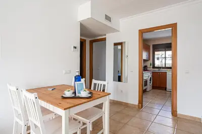 a kitchen and dining room with a wooden table and chairs at coto 2 18 in Chiclana de la Frontera