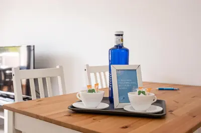 a bottle of wine and two cups on a wooden table at coto 9 16 in Chiclana de la Frontera