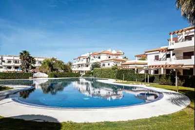 a swimming pool in front of some apartment buildings at coto 4 17 in Chiclana de la Frontera