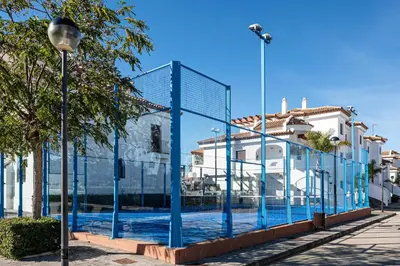 a fence with blue poles in front of some buildings at coto 8 22 in Chiclana de la Frontera
