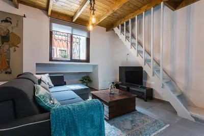 a living room with a couch and a tv at Duplex Los Corceles Casa Palacio in Jerez de la Frontera
