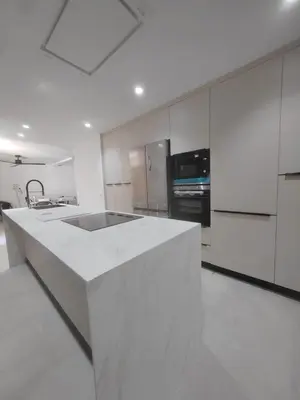 a white kitchen with a large white counter top at Casa Isabel in Chipiona