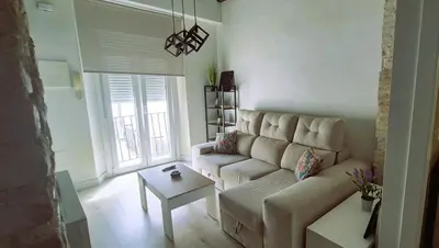 a living room with a couch and a table at Ático de Goleta by Gades Gestión in Cádiz