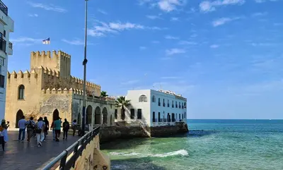 a group of people walking on a pier next to the ocean at YourHouse Apartamentos Andasol 1D in Chipiona