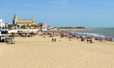 a group of people on a beach near the ocean at YourHouse Apartamentos Andasol 1D in Chipiona