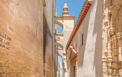 an alley in the city with a tower in the distance at 1 Bedroom Nice Apartment In Arcos De La Frontera in Arcos de la Frontera