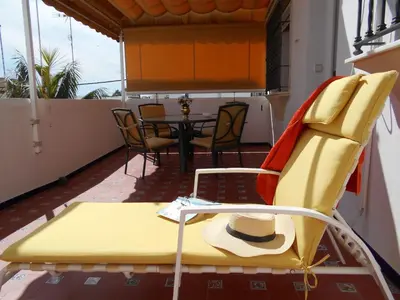 a yellow chair and a table on a balcony at Holiday Home Touristenwohnung Apartment mit Terrasse by Interhome in Chipiona