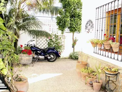 a motorcycle parked next to a building with potted plants at Apartment Wohnung 'Caracola' mit Terrasse by Interhome in Chipiona