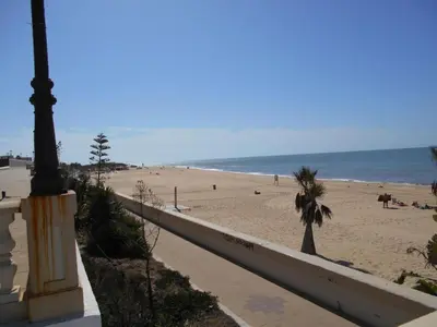 a view of a beach with people on the sand at Apartment Wohnung 'Caracola' mit Terrasse by Interhome in Chipiona