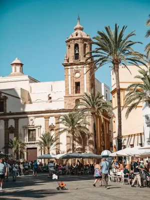 a large building with a clock tower in a city at Hidden Gem PLAYA DE SANTA MARÍA SUITES by ApartmentsinCadiz in Cádiz