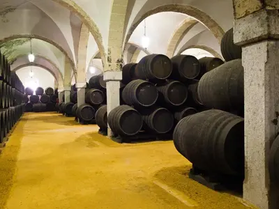 a row of wine barrels in a wine cellar at Sherryflat Mérito - Parking in Jerez de la Frontera
