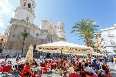 a group of people sitting at tables in front of a building at Casa TANGUILLOS de Cadiz in Cádiz